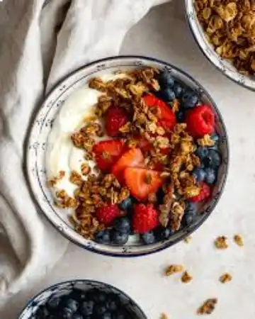 Bowl de iogurte grego com frutas vermelhas e castanhas para energia pré-treino